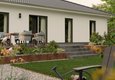 Moderne Terrasse des Bungalow 110 von Town & Country Haus mit Sitzgruppe, bodentiefen Fenstern und gepflegter Gartenanlage
